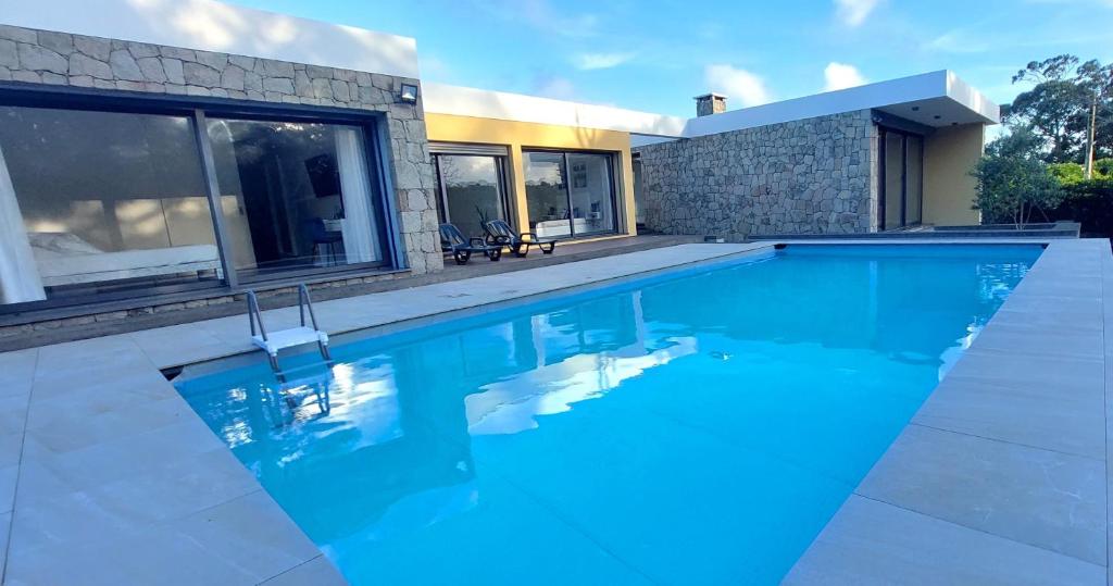 Fonte do BustardoCasa Azul Terceira Island Azores的一座房子前面的蓝色海水游泳池