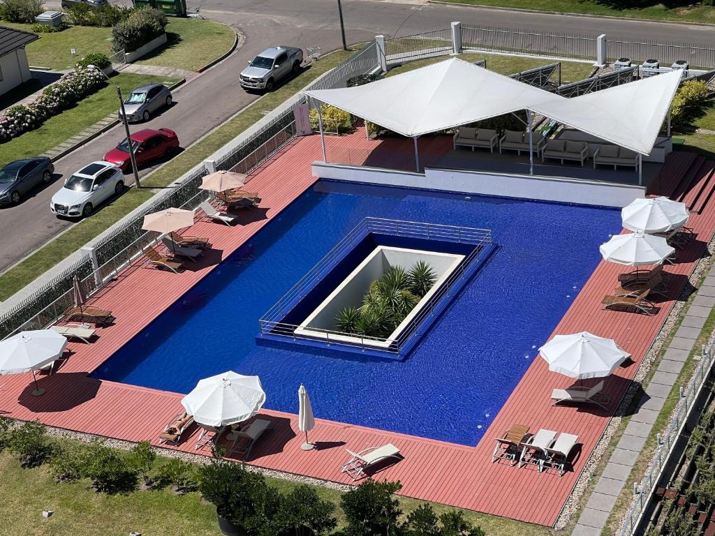 埃斯特角城Punta del Este - Green Life - Top amenities的享有带椅子和遮阳伞的游泳池的上方景色
