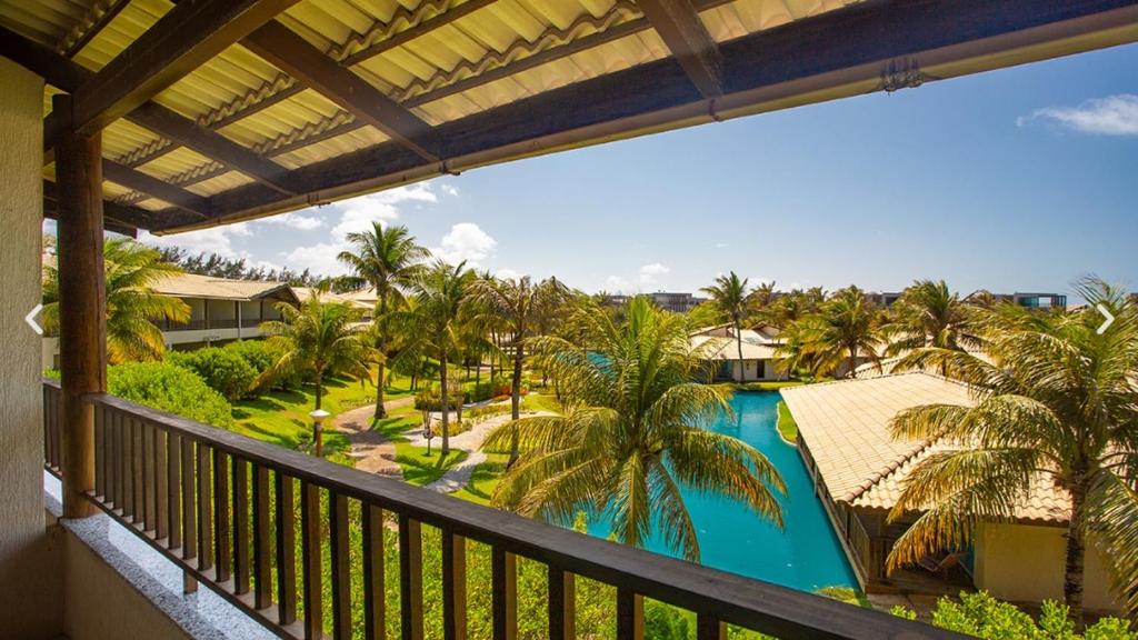 福塔莱萨Dom Pedro Laguna Beach Resort & Golf的享有游泳池和棕榈树景致的阳台