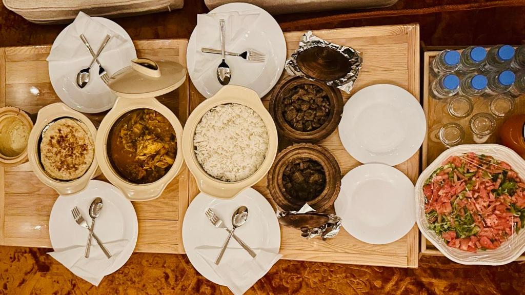 BadīyahSafari Infinity Camp的餐桌,盘子,碗,食物和汤匙