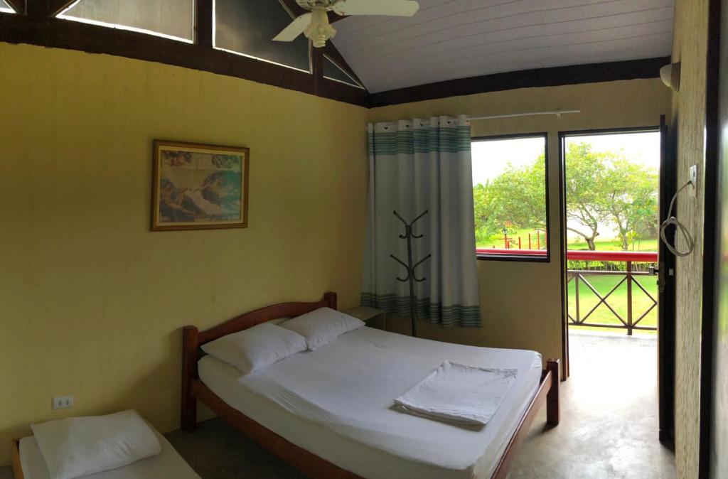 塔曼达雷Chalé Verde的一间卧室设有一张床和一个大窗户