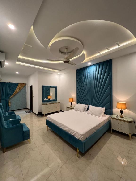 伊斯兰堡The Gateway islamabad的一间卧室配有一张大床和一张蓝色椅子