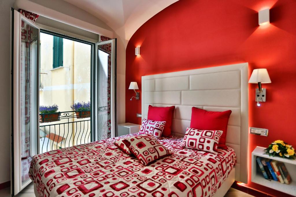 阿马尔菲Amalfi Apartments Design centro storico的一间卧室设有红色的墙壁和一张带红色枕头的床