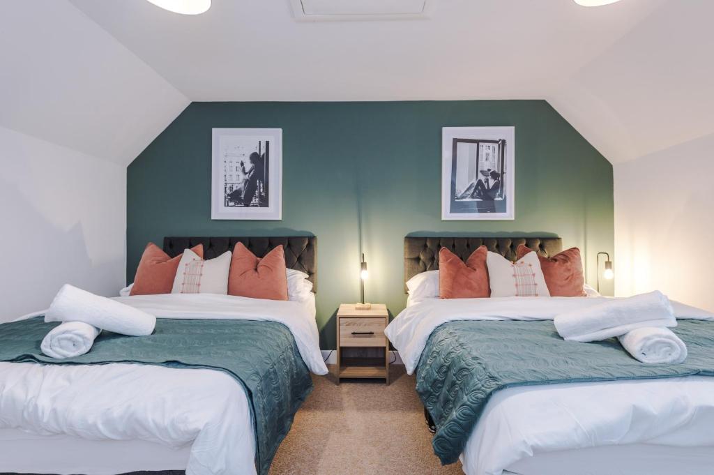 特伦特河畔斯托克Beautiful Stoke Home Sleeps 10 by PureStay Short Lets的一间卧室设有两张床和绿色的墙壁