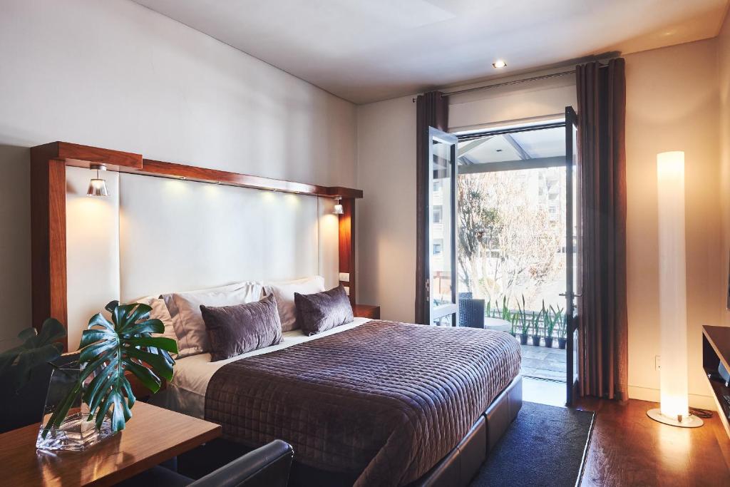 开普敦Hotel on the Promenade的一间卧室设有一张床和一个大窗户