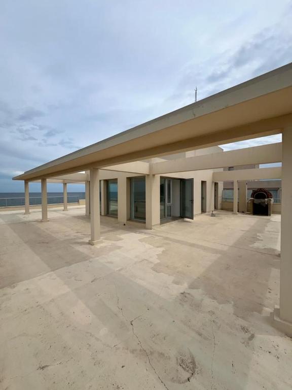 埃斯特角城Penthouse Villa brava的一座大建筑,有屋顶,后面有海洋