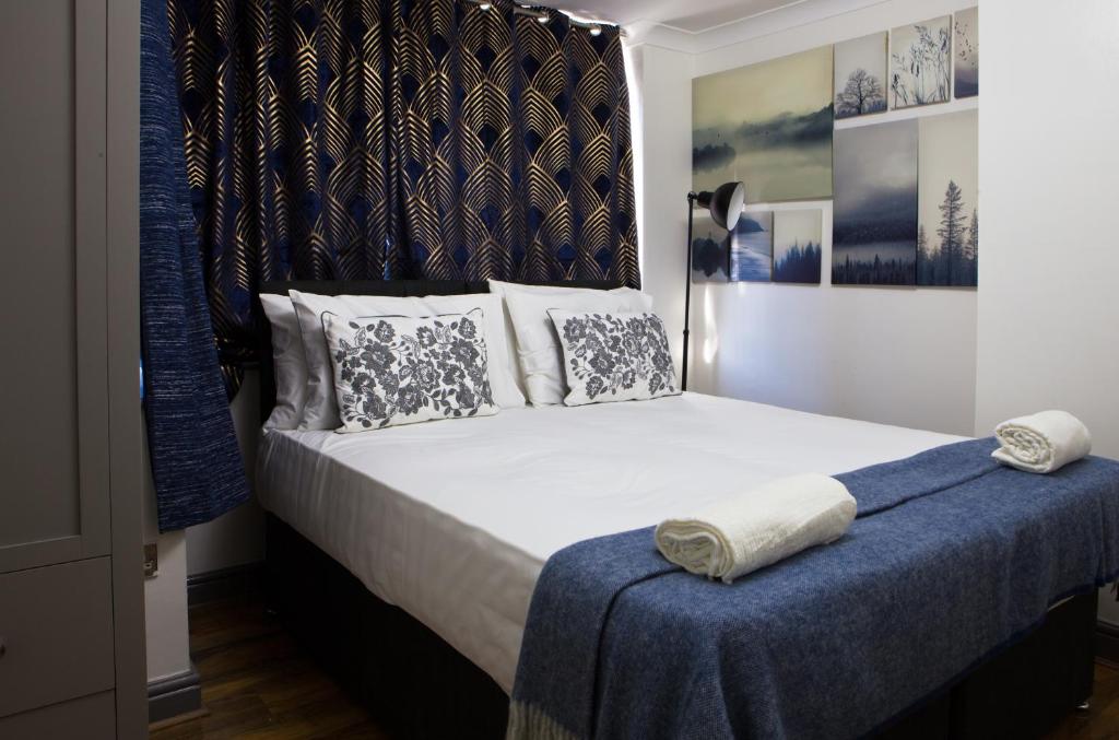 Hatch EndSleek 3Bed/3Bathroom Flat@Harrow的一间卧室配有一张带蓝色毯子的大床