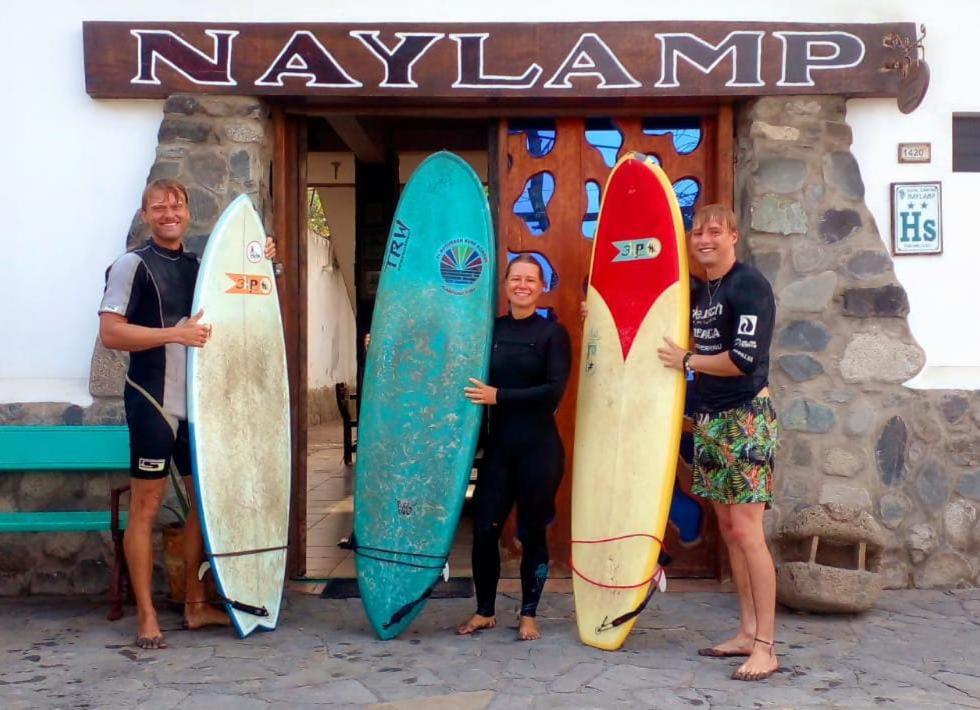 万查科Hostal Naylamp的一群人站在一个装有冲浪板的商店前