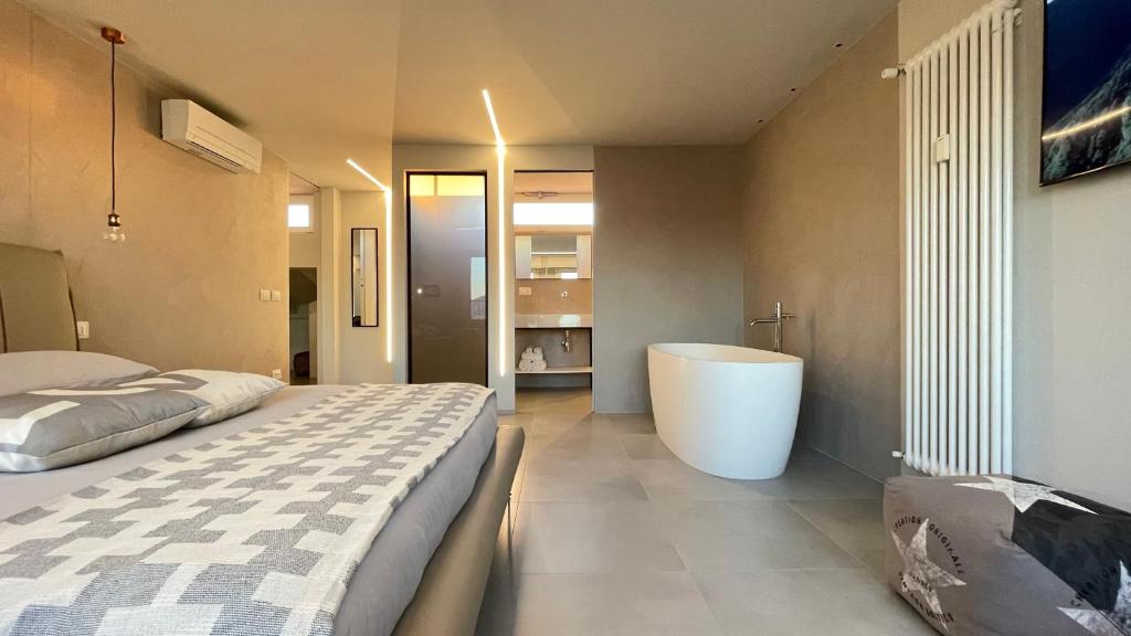 比萨美地西奥42号公寓的一间卧室设有一张大床和一个浴缸
