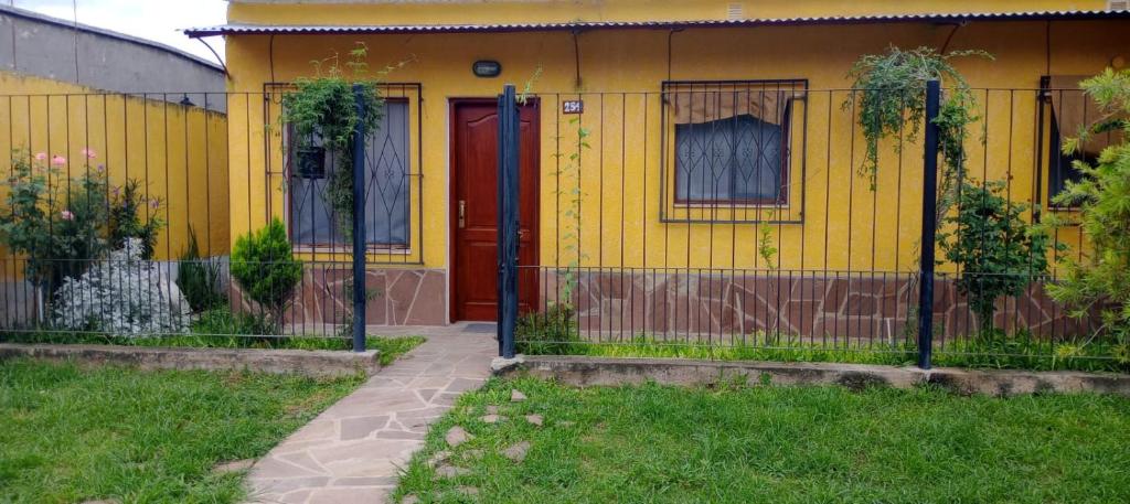 El CarmenLa Nona的黄色的房子,有红色的门和栅栏