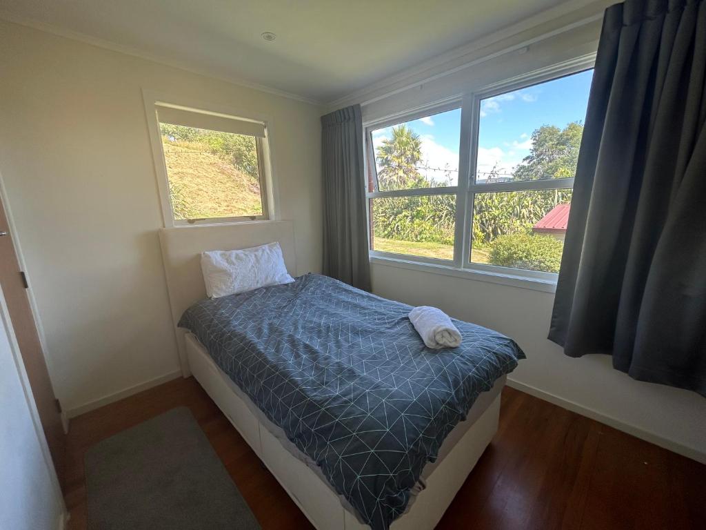 罗托鲁瓦Rotorua Lakes House的一间小卧室,配有床和2个窗户