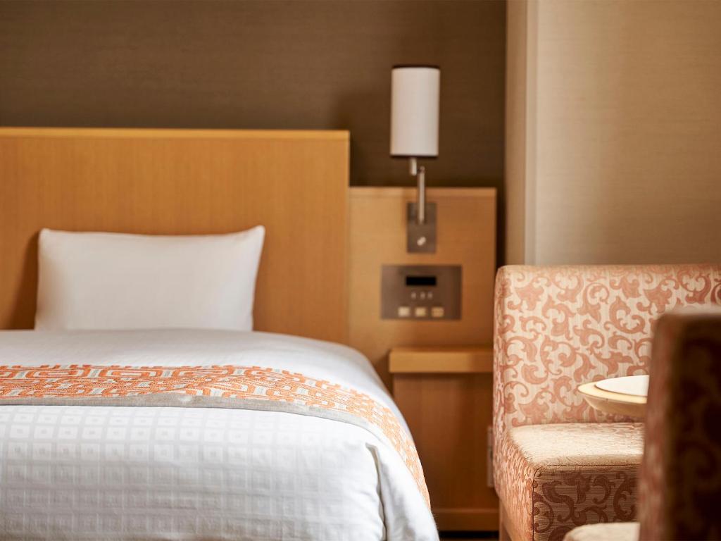 广岛广岛戴哇鲁内酒店的配有一张床和一把椅子的酒店客房