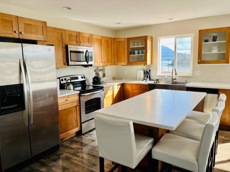 MendenhavenAuk Nu, Cove View Alaskan Home的厨房配有不锈钢冰箱和木制橱柜