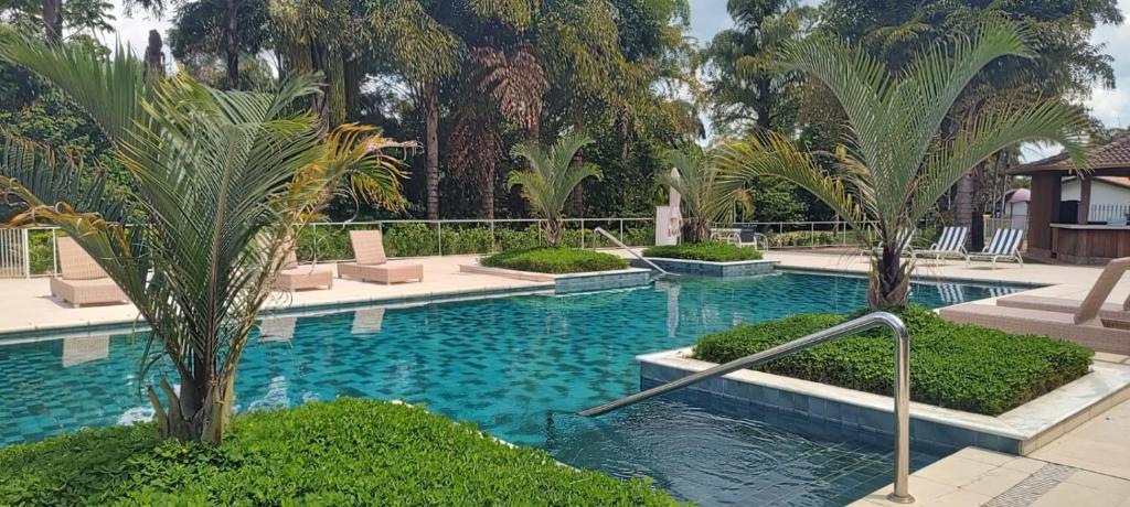 塞拉内格拉Radio Hotel Resort & Convention的度假村内棕榈树游泳池