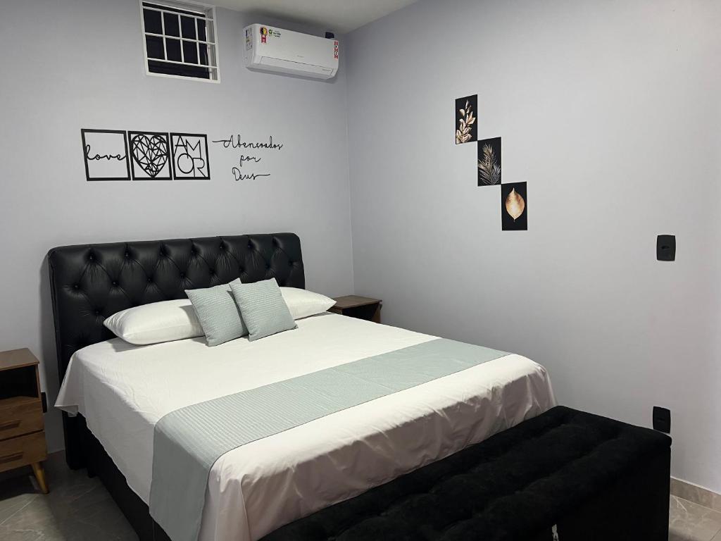 戈亚斯Kitnet Cidade de Goiás - Go #02的一间卧室配有一张大床和黑色床头板