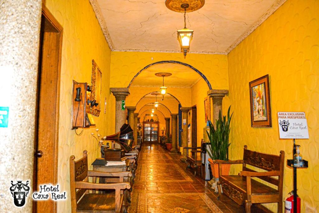 科马亚瓜Hotel Caxa Real的走廊,建筑有黄色的墙壁和木桌