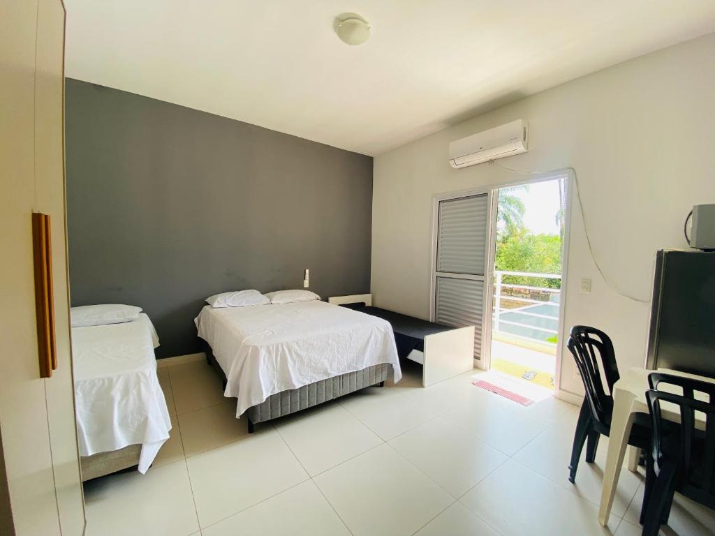 伯迪亚哥Suíte privativa proxima ao Sesc 2的一间卧室配有一张床、一张书桌和一个窗户。