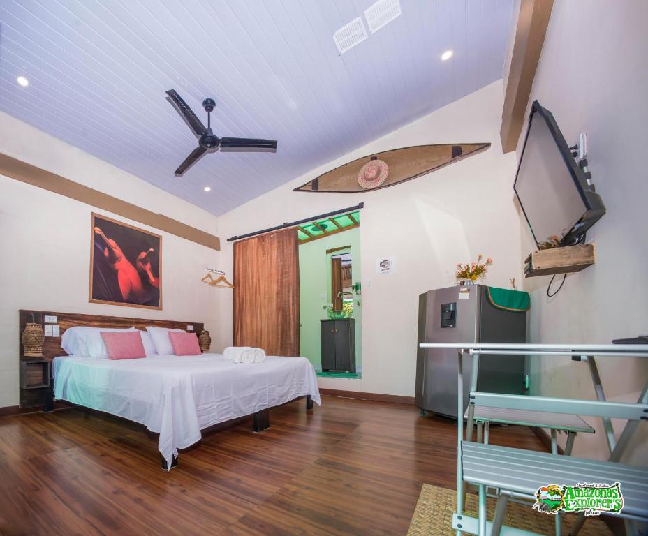 莱蒂西亚AMAZONAS EXPLORERS LETICIA的卧室配有一张床,墙上设有冲浪板