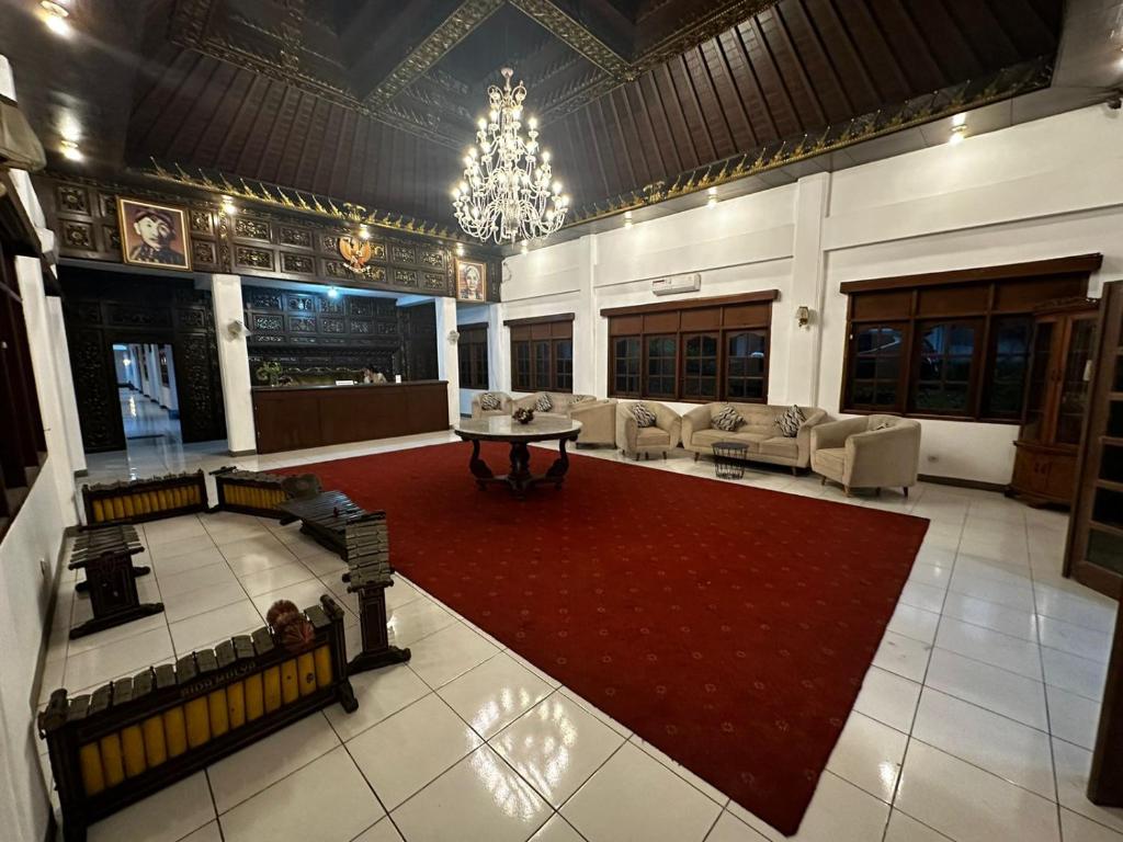 KartosuroSadinah Sahid By Meliala的一间大房间,配有沙发和红色地毯