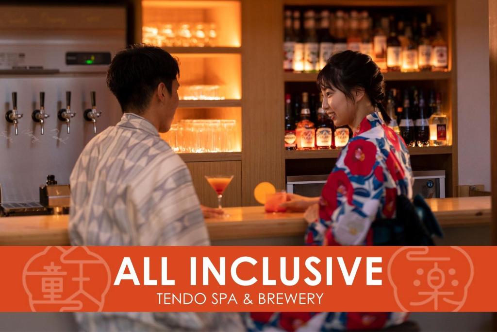 天童市Ichiraku tendo spa & brewery的站在酒吧的男人和女人