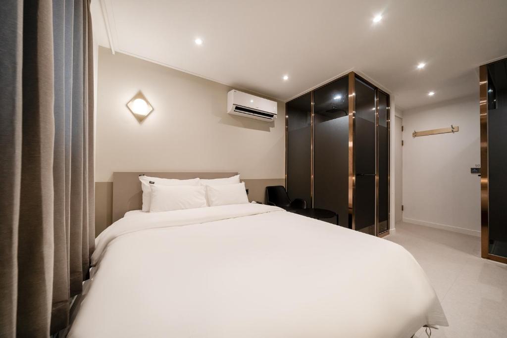 首尔Baron De Hotel的卧室配有一张白色大床和一个衣柜