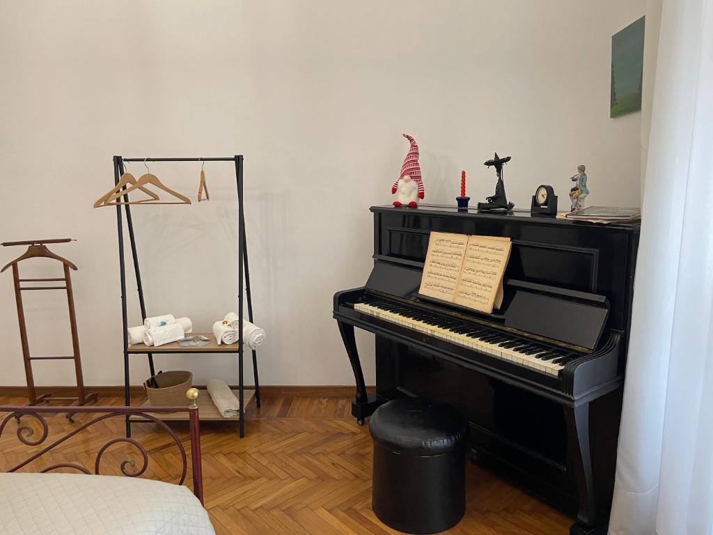 都灵Coli's House的一间有标志的房间的黑钢琴