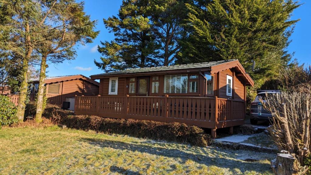 特兹西尼德Snowdonia Log cabin的一座带甲板和房子的度假屋