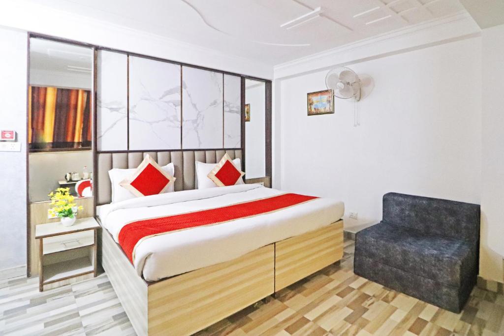 新德里Hotel Clink Stay Near Delhi IGI Airport的一间卧室配有一张床和一把椅子