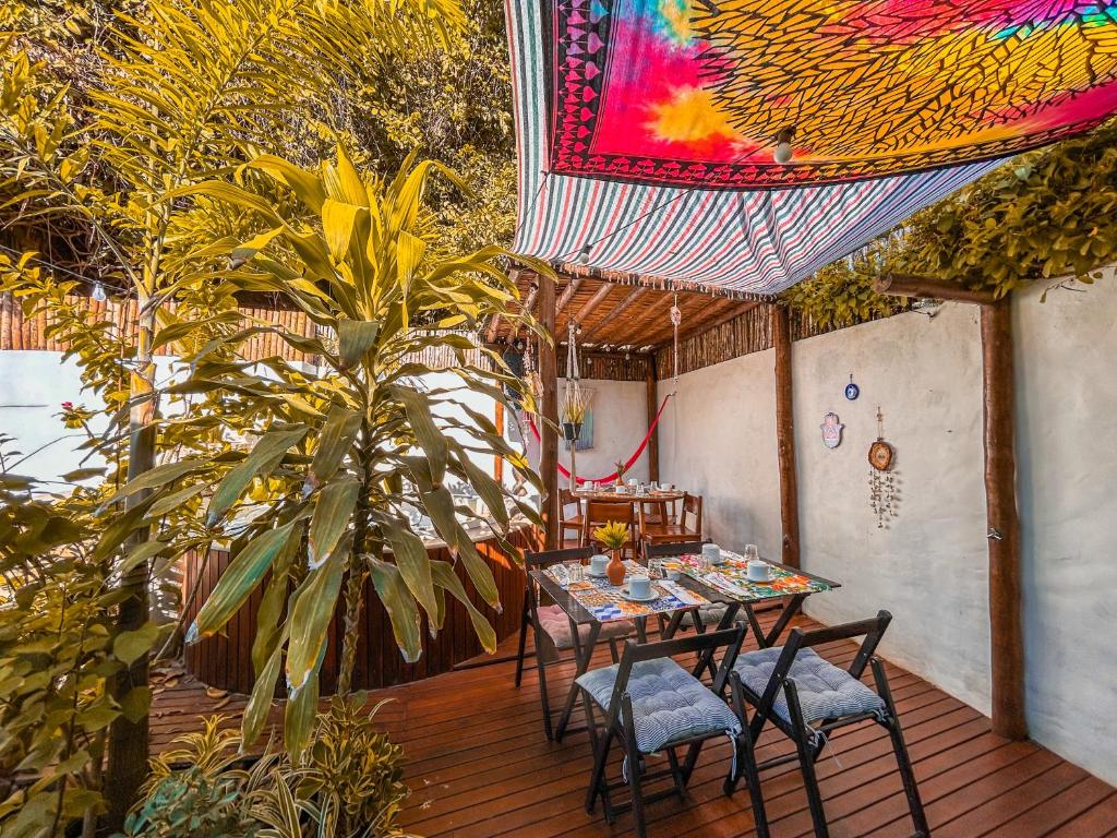 佩德拉斯港Maruê Guesthouse Porto de Pedras的庭院设有桌椅和色彩缤纷的天花板。