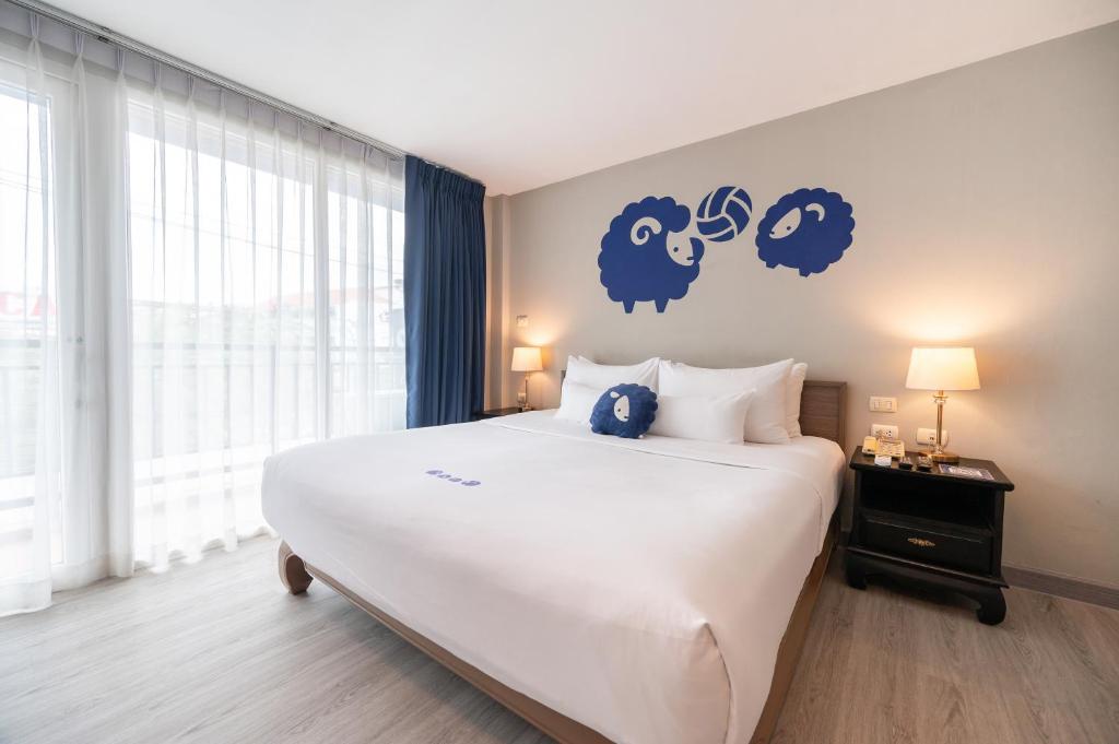 奥南海滩甲米奥南科科酒店的卧室配有一张大床,墙上挂着蓝色标志