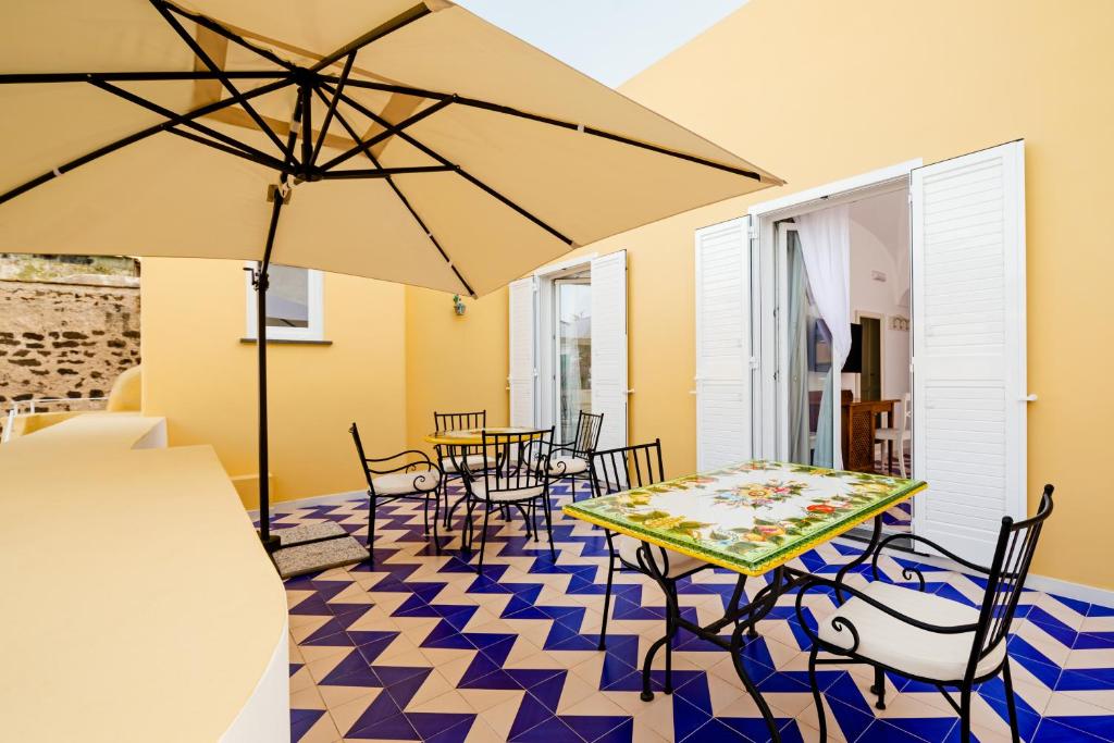 伊斯基亚大拉斐尔酒店 的庭院配有桌椅和遮阳伞。