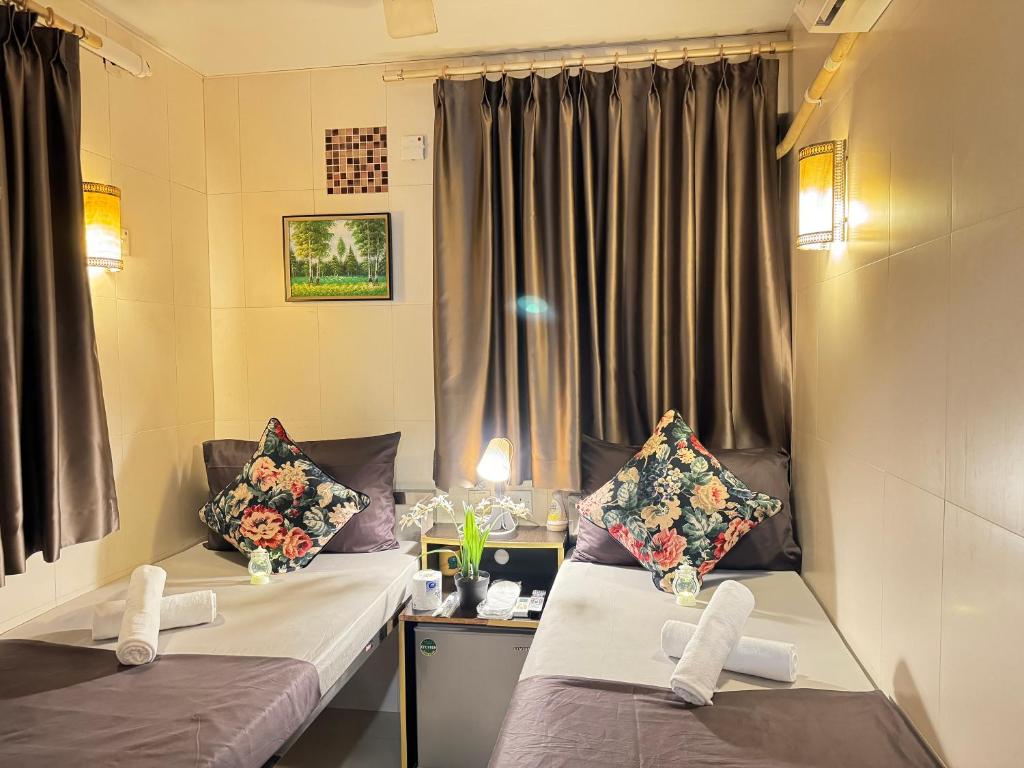 香港International Inn的客房设有两张床、一张桌子和一个窗户。