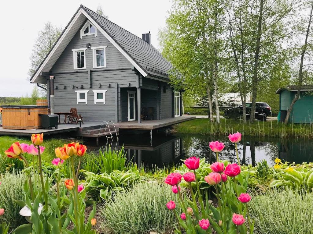 ErmistuErmistu Puhkeküla的前沿的码头上一座鲜花盛开的房子