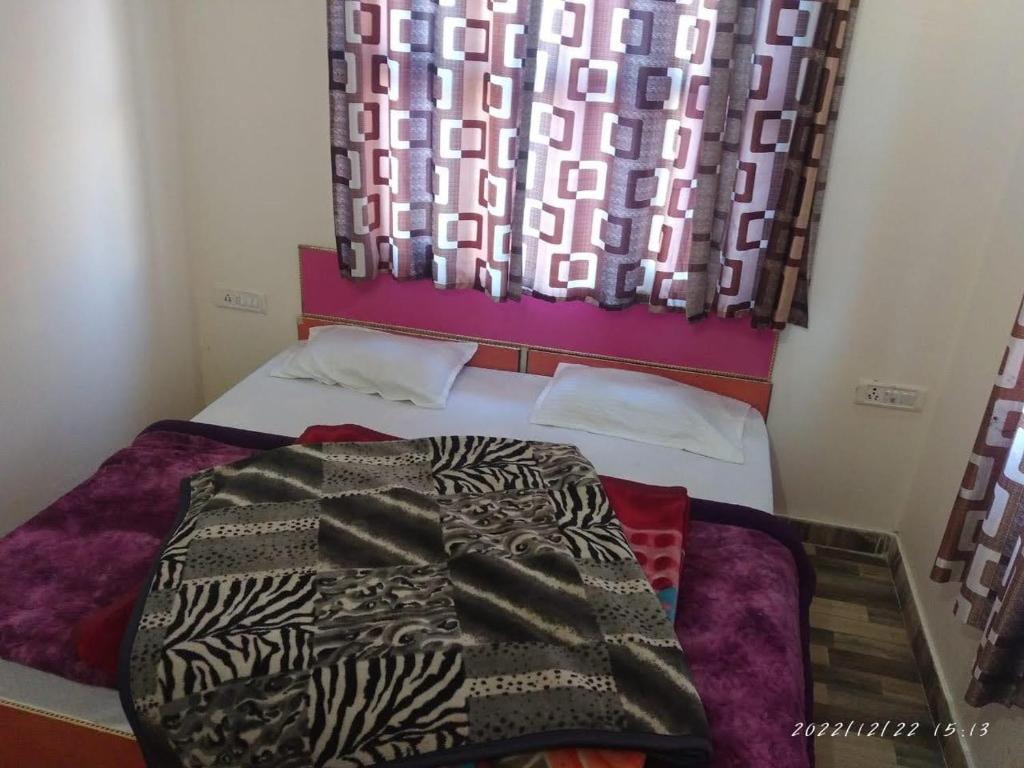 乔斯希马特Hotel Rocks and pine Auli的一间卧室配有一张床铺,床上有毯子