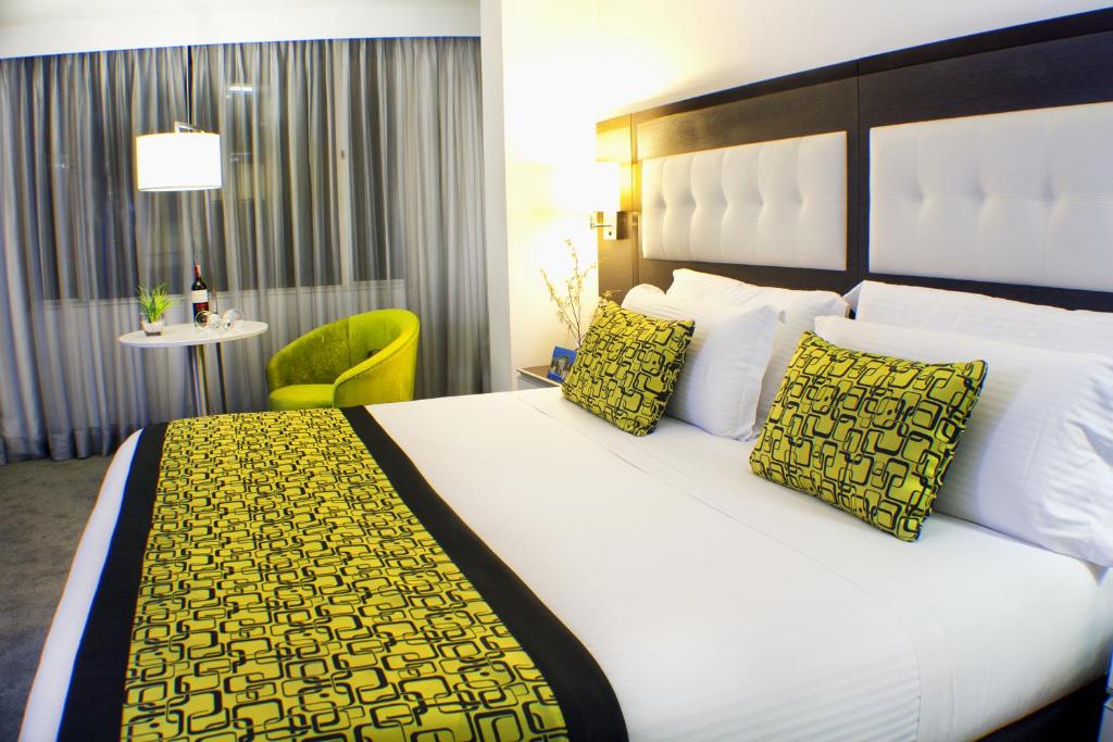 波哥大Hotel City Bog Expo Museo的酒店客房配有一张带黄色枕头的大床