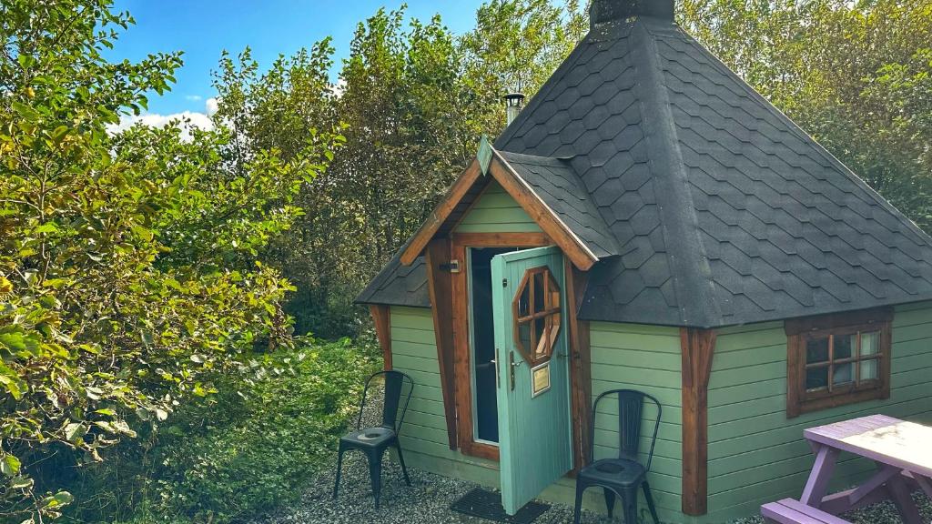 邓韦根Skye Eco Bells的一个带屋顶的小棚子和桌椅
