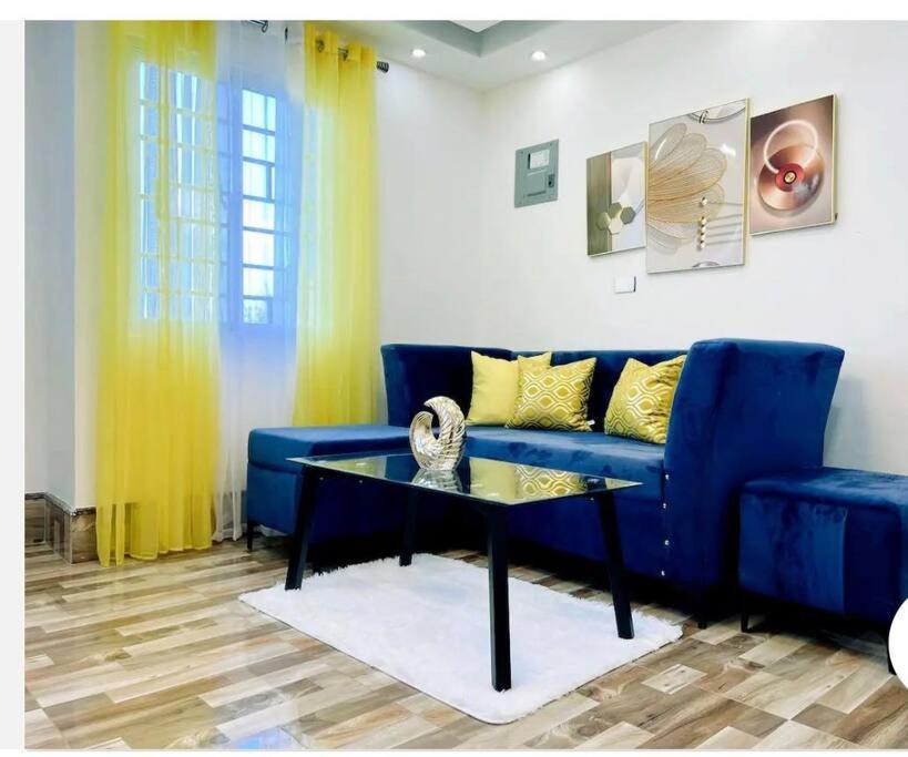 博卡奇卡JC caribe Aparta Hotel #7的客厅配有蓝色的沙发和桌子