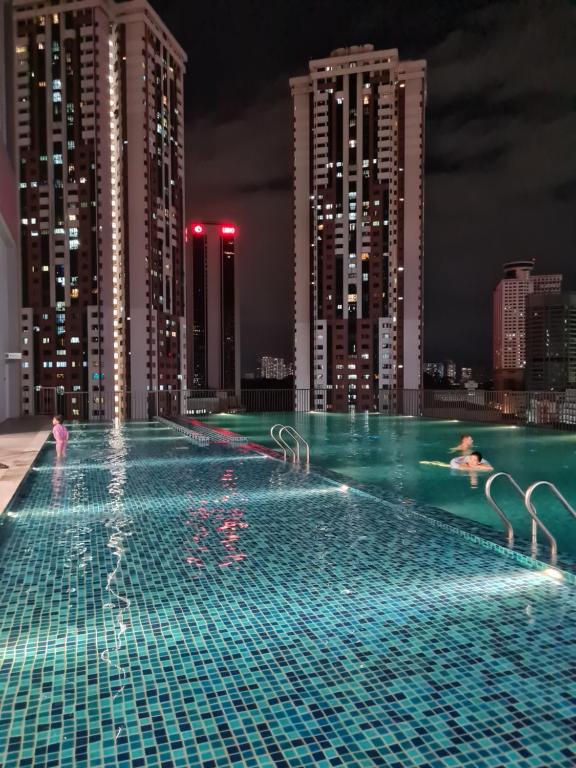 吉隆坡Chambers Suites KLCC by Moonlight的游泳池在城市顶端的夜晚