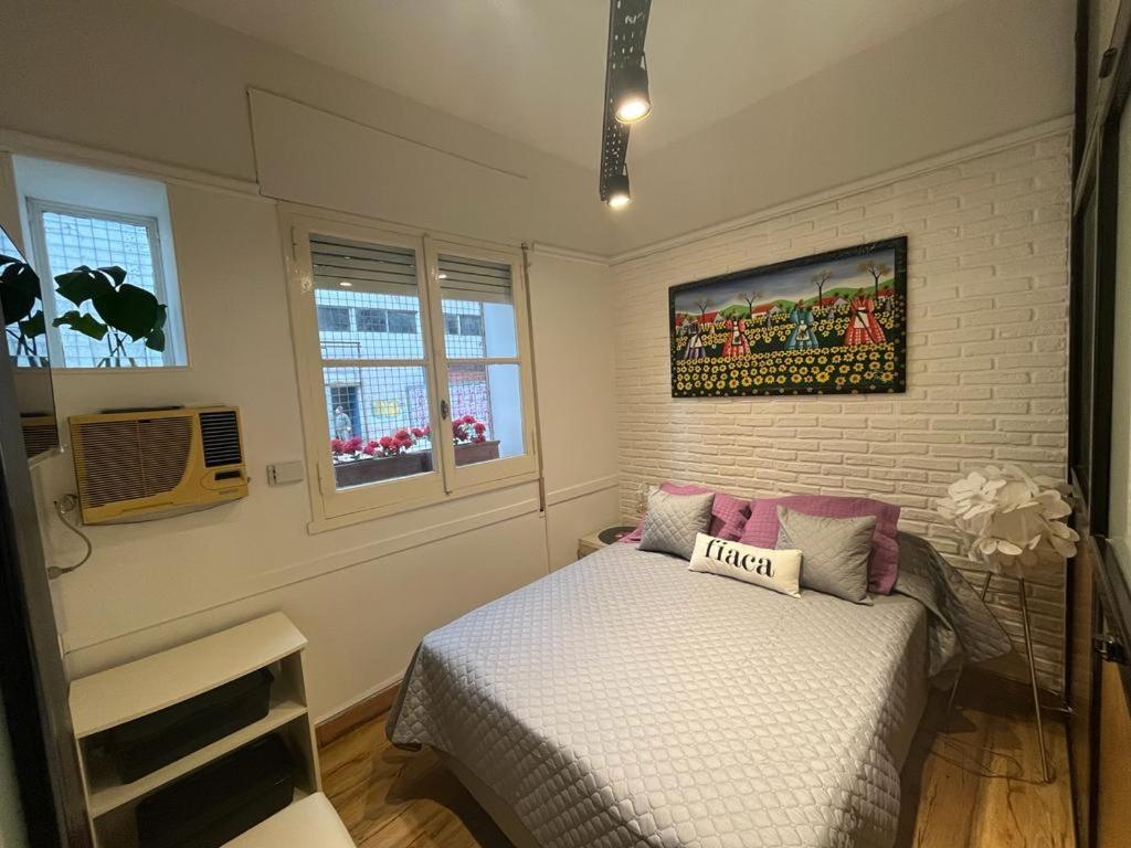 布宜诺斯艾利斯Confortable and Cozy Apartment in Palermo - Cañitas的卧室配有一张床,墙上挂有绘画作品