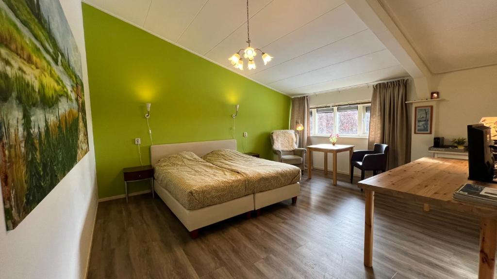 泽沃德德斯坦霍夫酒店的一间卧室设有一张床和绿色的墙壁