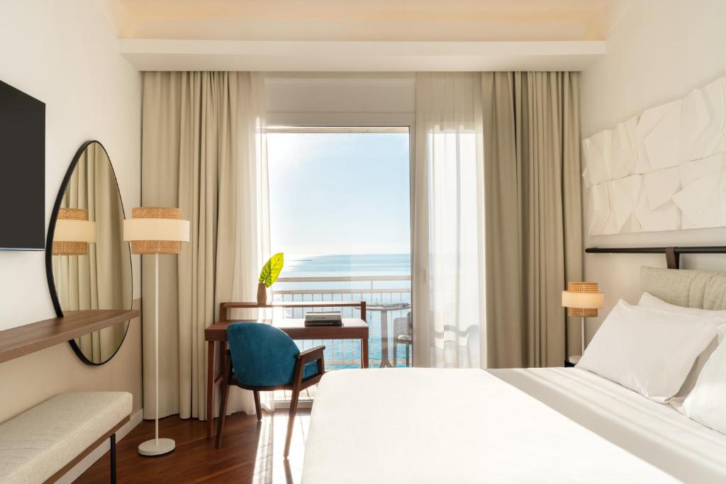塔兰托Hotel Delfino Taranto的配有一张床、一张书桌和一扇窗户的酒店客房