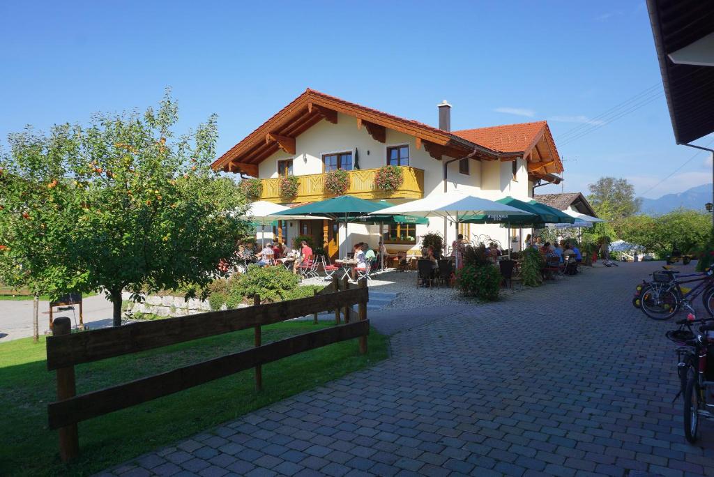 基姆湖畔贝尔瑙Cafe Wastelbauerhof - Urlaub auf dem Bauernhof的街道上带桌子和遮阳伞的建筑