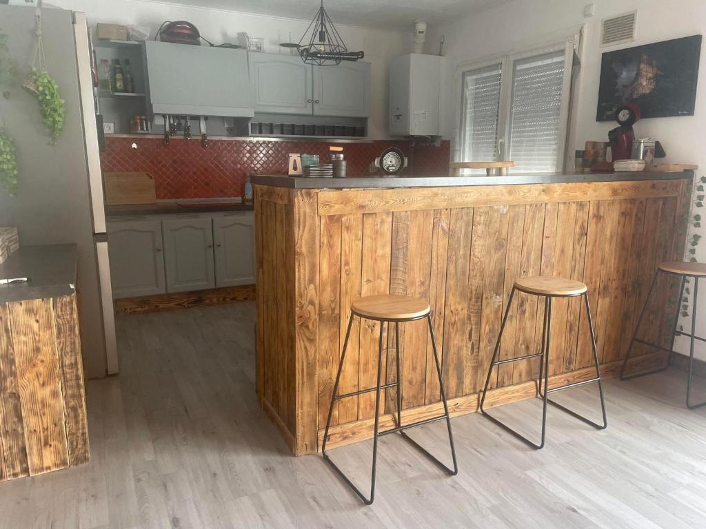 兰斯Le Ranch - proche centre ville的厨房配有木台和2张凳子
