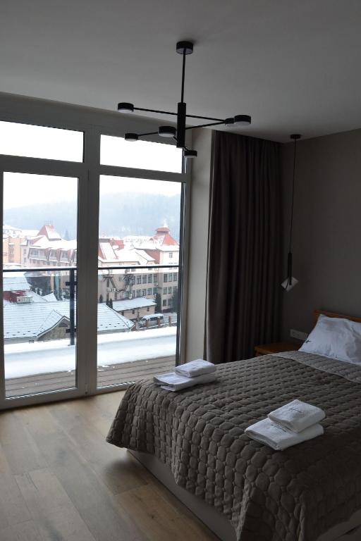 波利亚纳Village apartments Polyana的一间卧室设有一张床和一个大窗户