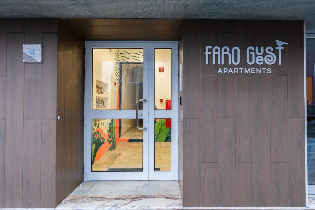 法鲁Faro Guest Apartments的建筑物的前门,上面有标志