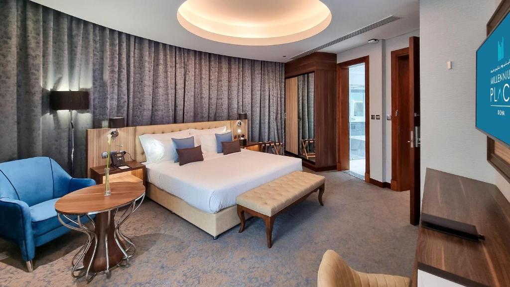 多哈Millennium Place Doha的酒店客房,配有一张床和一张蓝色椅子