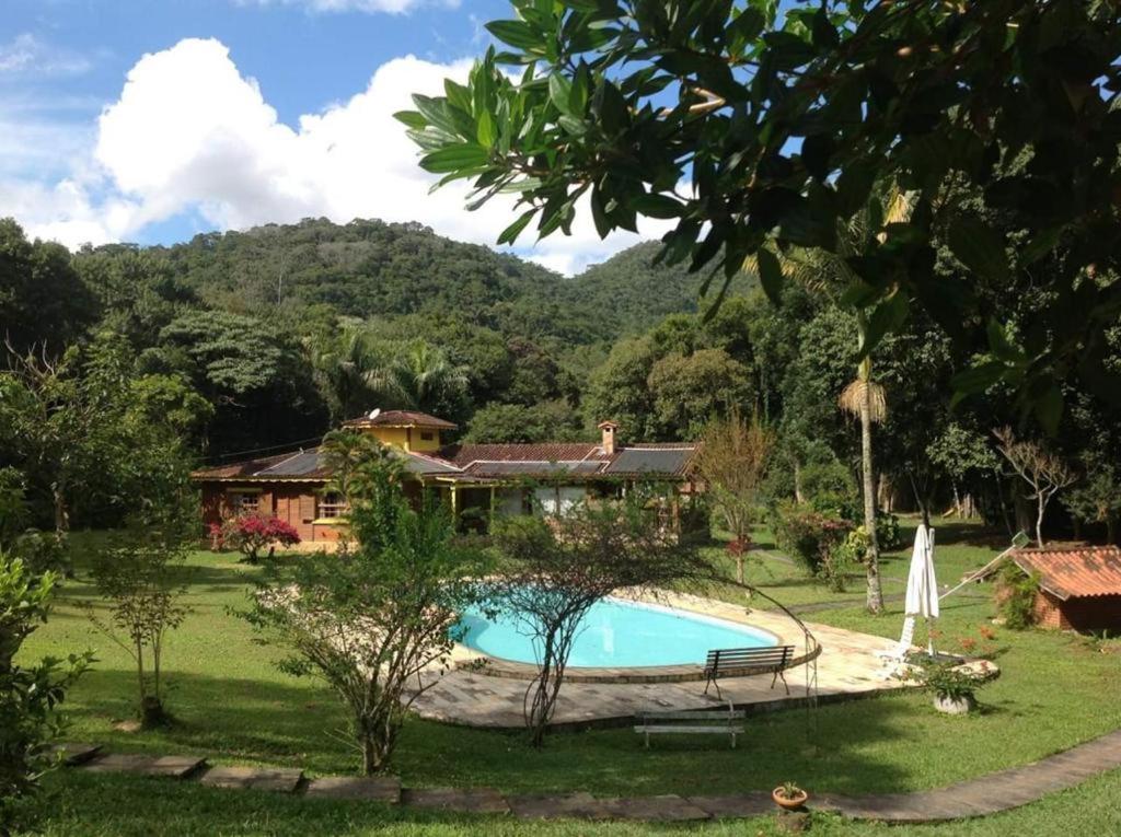特雷索波利斯Aldeia Gaia Chalés的庭院中带游泳池的房子