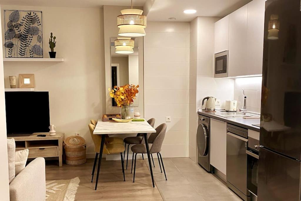 塞维利亚Nuevo Moderno Apartamento de Lujo的一间带桌子的厨房和一间带用餐室的小厨房