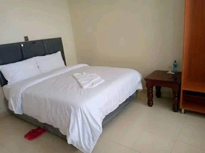 尼耶利Sagada Resort Lamuria的卧室配有一张白色的大床和一张桌子