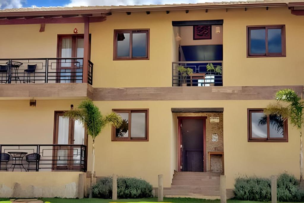 戈亚斯州上帕莱索Canto do Paraíso - Aluguel para Temporada的带阳台的黄色房屋